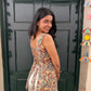 Woman standing in front of a black door with colorful decorations above.