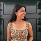 Woman in a patterned dress standing in front of a dark green door
