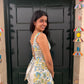 Woman standing in front of a black door with decorative elements above.