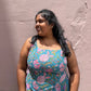 Woman wearing a floral dress against a plain wall
