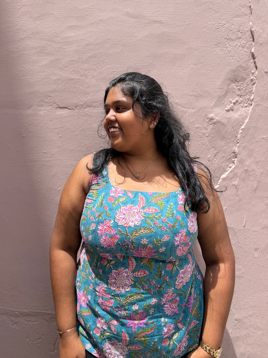 Woman wearing a floral dress against a plain wall